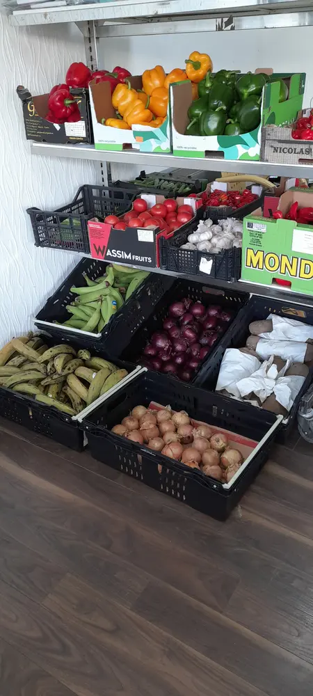 Crates of peppers, plantain, tomatoes, garlic and onions on the shop shelves